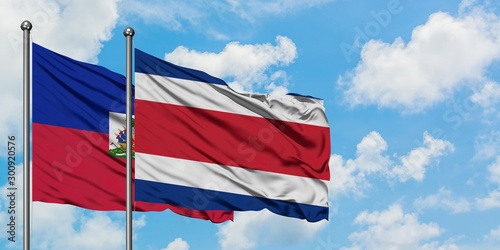 Haiti and Costa Rica flag waving in the wind against white cloudy blue sky together. Diplomacy concept, international relations.