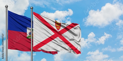 Obraz na płótnie Haiti and Jersey flag waving in the wind against white cloudy blue sky together