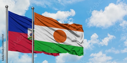 Φωτογραφία Haiti and Niger flag waving in the wind against white cloudy blue sky together