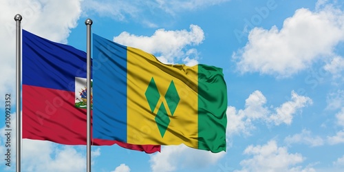 Εκτύπωση καμβά Haiti and Saint Vincent And The Grenadines flag waving in the wind against white cloudy blue sky together