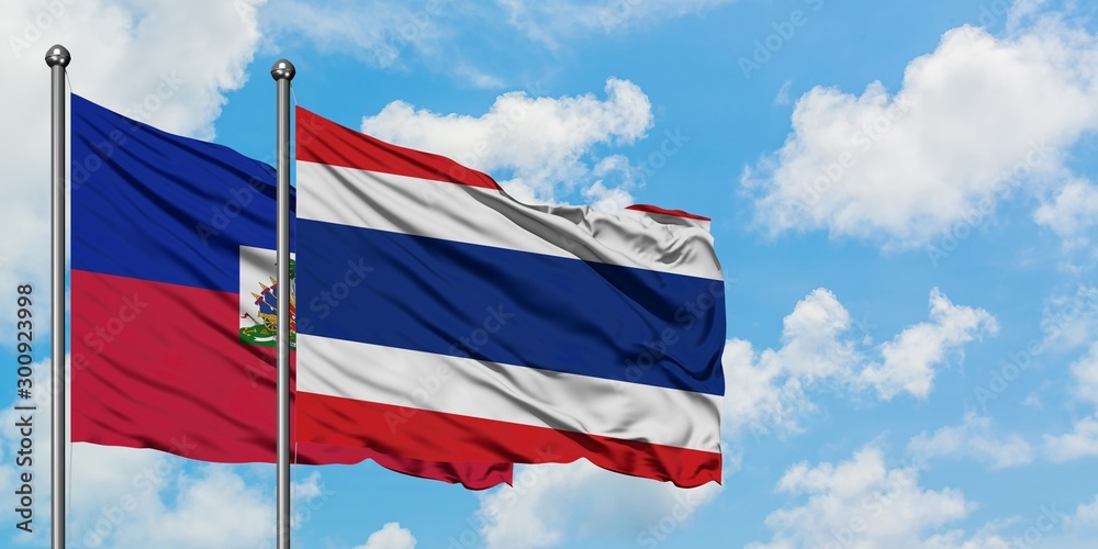 Haiti and Thailand flag waving in the wind against white cloudy blue sky together. Diplomacy concept, international relations.