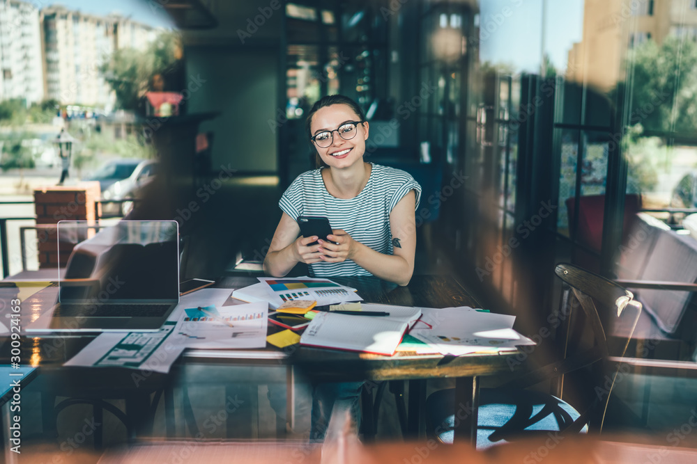 Smiling woman at table with papers in cafe Smiling woman at table with papers in cafe