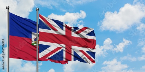 Φωτογραφία Haiti and United Kingdom flag waving in the wind against white cloudy blue sky together