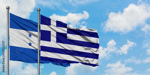 Honduras and Greece flag waving in the wind against white cloudy blue sky together. Diplomacy concept, international relations.