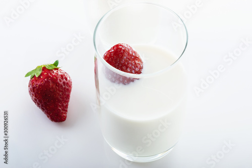Fresh  juicy strawberry in cream on white background. Close up. Selective focus. High key.