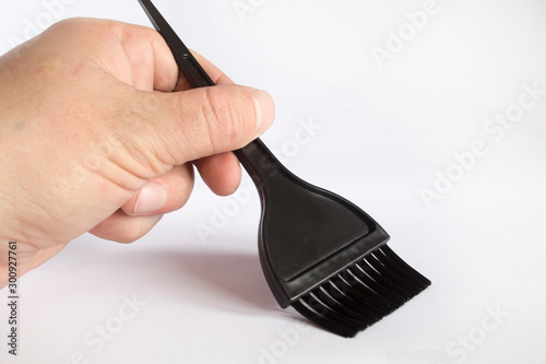 Black brush for coloring hair in hand on a white background.