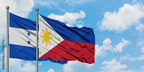 Honduras and Philippines flag waving in the wind against white cloudy blue sky together. Diplomacy concept, international relations.