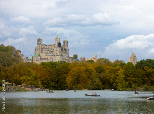 People row boats on The Lake in Central Park, New York City in autumn.