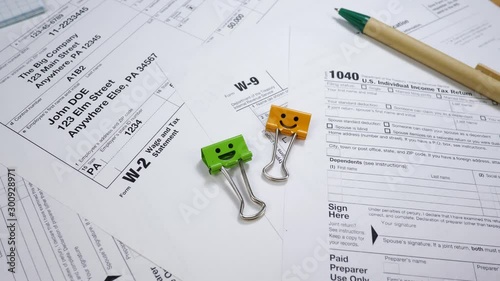 Taxes form 1040, document for W-2 and W-9 form. Smiles Binder Clips and Pen. Report in The Internal Revenue Service (IRS) of The United States of America (USA). Federal government concept photo