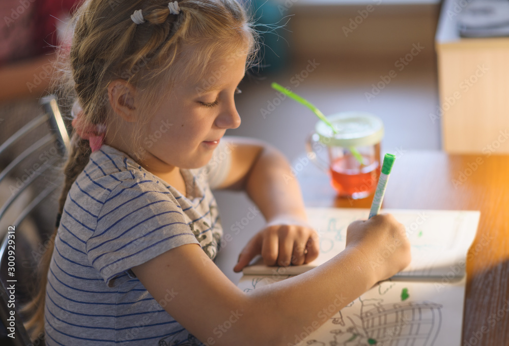 Cute little girl painting a picture in a home interior. Cute little girl painting a picture in a home interior.