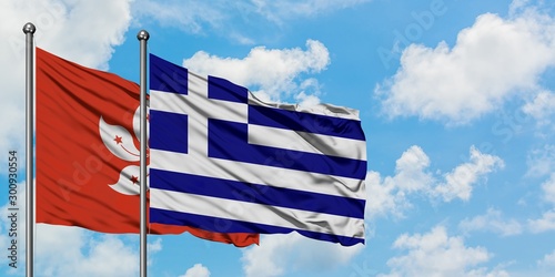 Hong Kong and Greece flag waving in the wind against white cloudy blue sky together. Diplomacy concept, international relations.