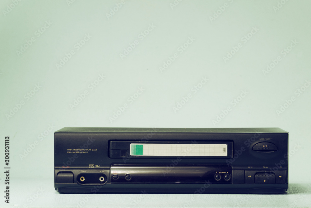 VHS video recorder Retro video recorder with video cassette on a light background film effect. VHS video recorder Retro video recorder with video cassette on a light background film effect.
