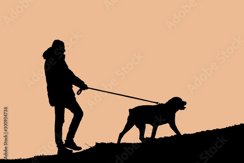 Silhouette image of young man with his pet,Rottweiler.