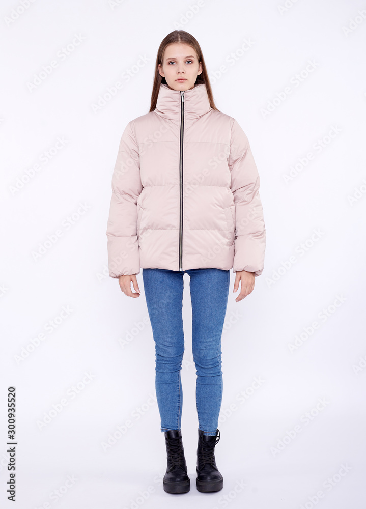 Young girl in a jasmine down jacket isolated on a white background. Young girl in a jasmine down jacket isolated on a white background.