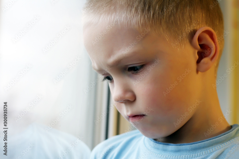Sad boy at the window, loneliness and depression Sad boy at the window, loneliness and depression