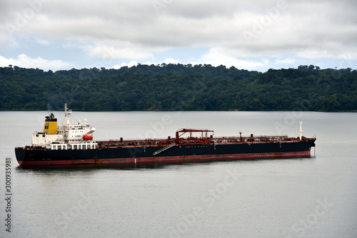 Tanker ship transiting through the Panama Canal on a cloudy day. 