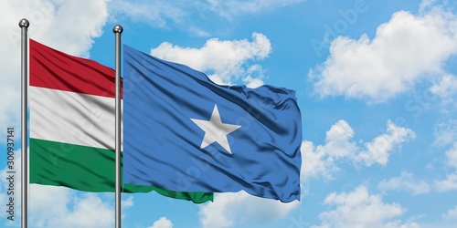 Hungary and Somalia flag waving in the wind against white cloudy blue sky together. Diplomacy concept, international relations.