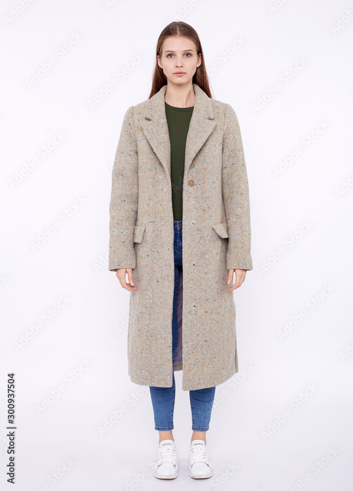 Beautiful fashion model in light gray long coat isolated on white background Beautiful fashion model in light gray long coat isolated on white background