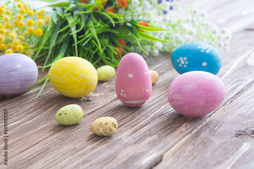 Colorful easter eggs with flowers on wooden board