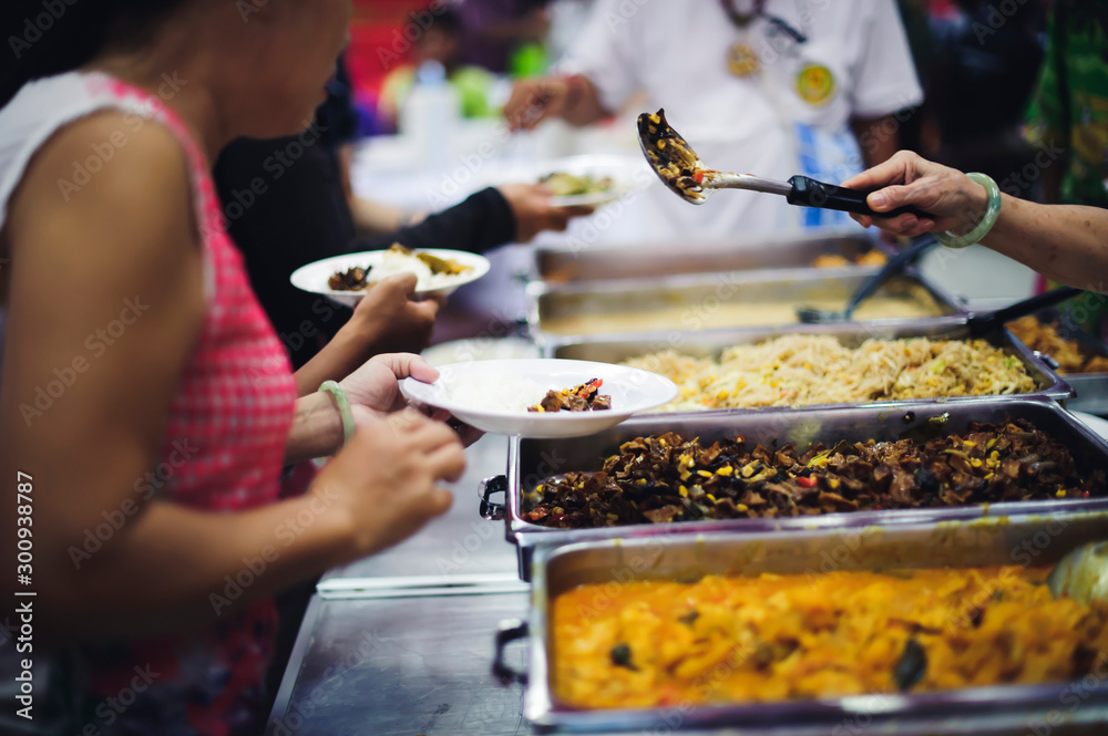 Fototapeta premium Refugees' hands are receiving food from philanthropists: the concept of hunger problems for the poor