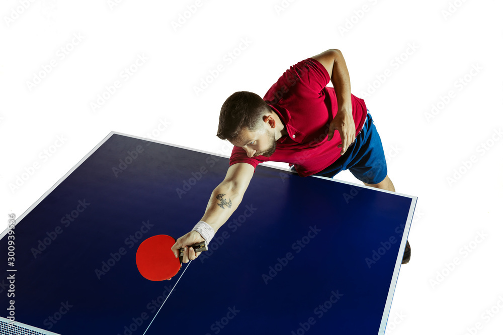 Foto Stock Strenuous. Young man plays table tennis on white studio  background. Model plays ping pong. Concept of leisure activity, sport,  human emotions in gameplay, healthy lifestyle, motion, action, movement. |  Adobe