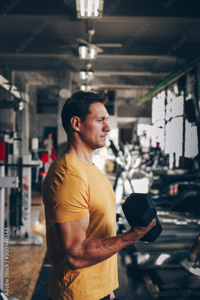authentic image, fit coach man lifting weight, training bicep curl in the gym. concept of weight loss and healthy living. authentic image, fit coach man lifting weight, training bicep curl in the gym. concept of weight loss and healthy living.