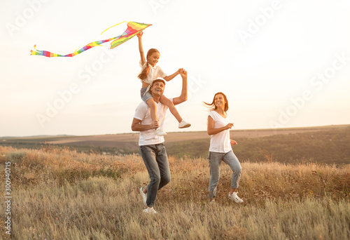 Delighted family playing with kite