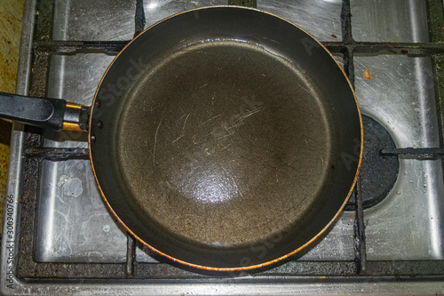 Non-stick frying pan on stainless steel gas stove. Home cooking.