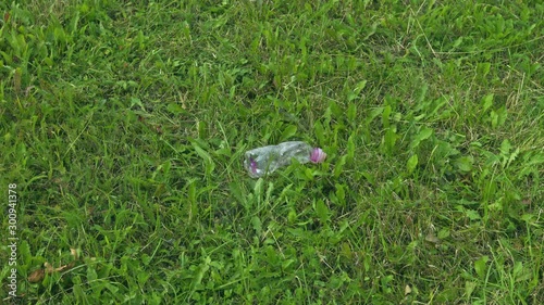 A plastic bottle is picked from a patch of grass, improving the environment photo