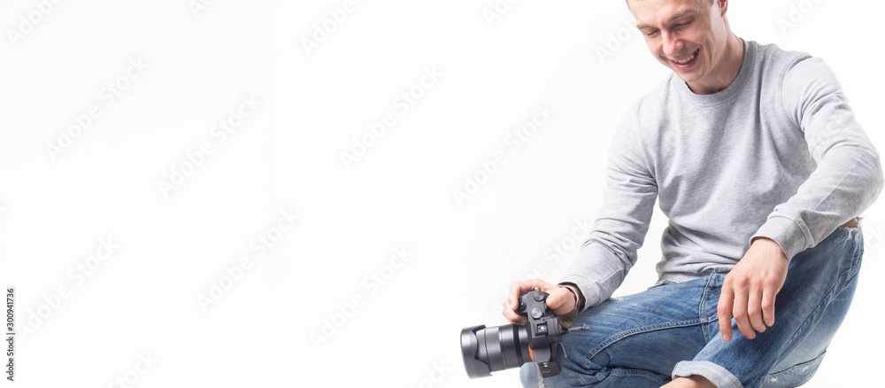 Professional photographer holding a camera in his hands. Studio portrait on a white background. Professional photographer holding a camera in his hands. Studio portrait on a white background.
