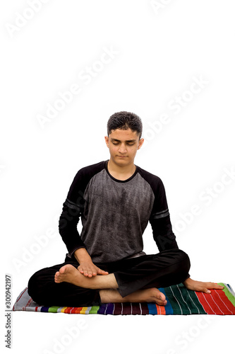 Full-length shot of male teenager in black sports outfit and doing Fire Log Yoga Pose or Agni Stambhasana isolated on white background. photo
