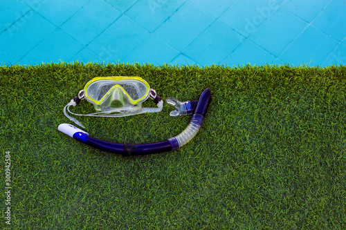 snorkeling mask and tube life style water activity hobby poster wallpaper picture with green grass and swimming pool background and empty copy space for your text here