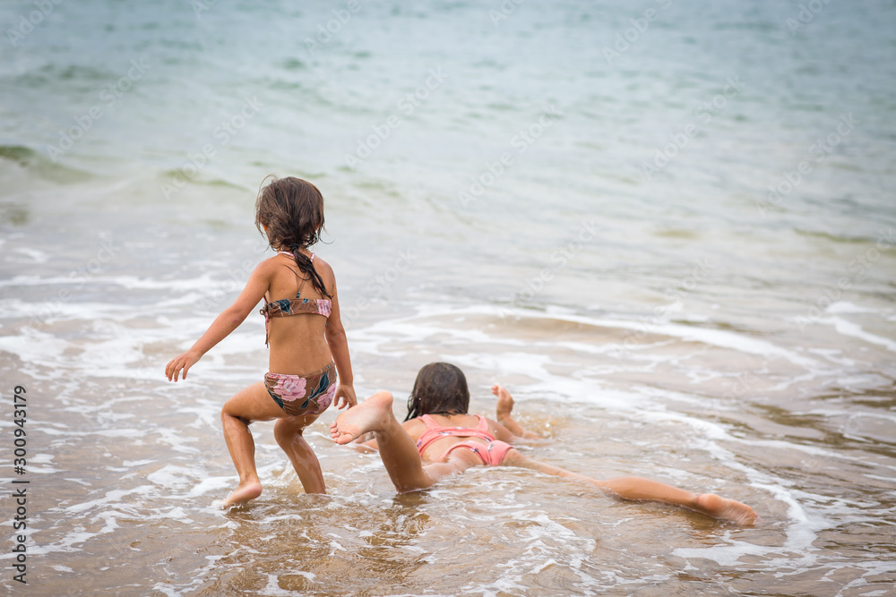 Two young girls playing in the Pacific Ocean Two young girls playing in the Pacific Ocean