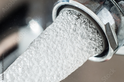 Foto Frozen water stream from a tap Close-up
