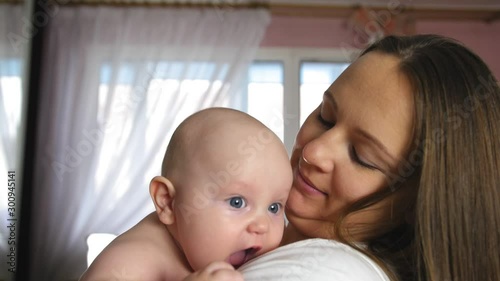 Mother and Baby. Happy young mother hugs chubby baby. Close up shot.
