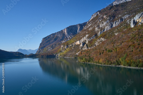 Aerial view of Lake Molveno, north of Italy. In the background Alps, blue sky. Autumn season. Multi-colored palette of colors