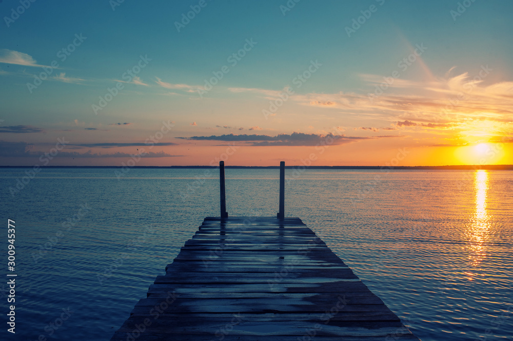 Wooden pier on forest lake or river during sunset, tinted Wooden pier on forest lake or river during sunset, tinted