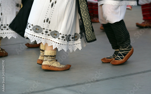 Dancers feet in a traditional Romanian dance wearing traditional beautiful costumes and peasant sandlas made of leather.