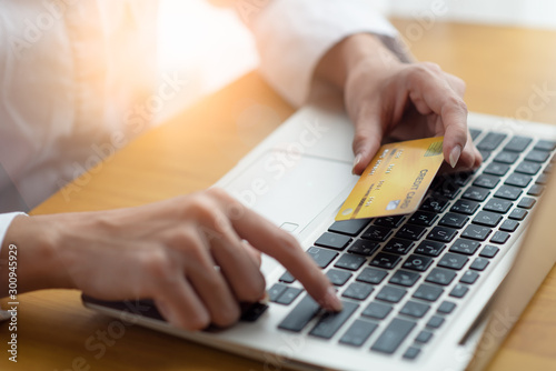 Fototapeta Naklejka Na Ścianę i Meble -  Woman holding credit card and using laptop for online shopping