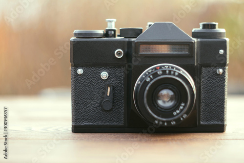 Close up of vintage camera, old retro technology at wooden table, blurred background