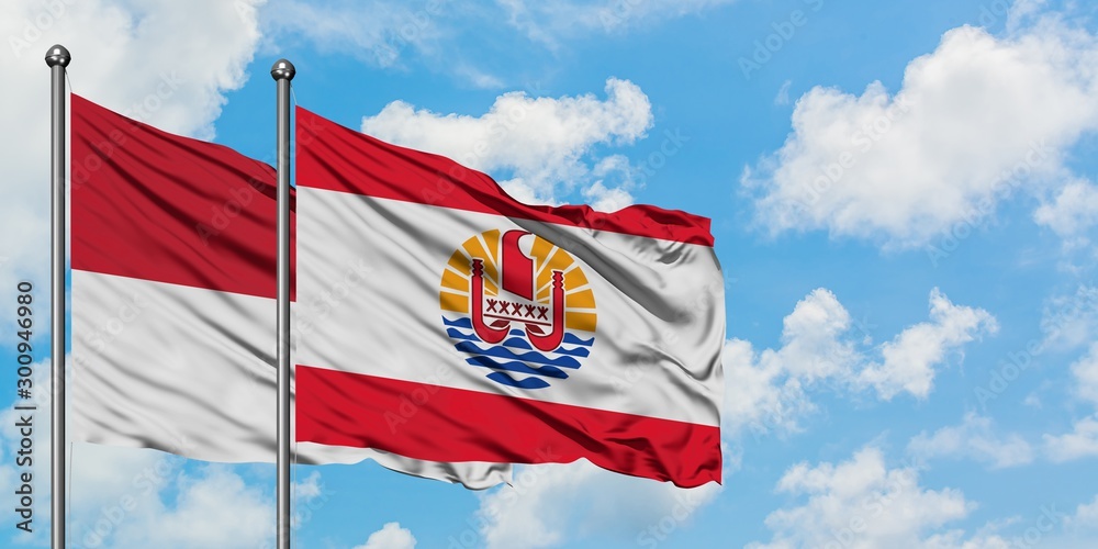 Naklejka premium Iraq and French Polynesia flag waving in the wind against white cloudy blue sky together. Diplomacy concept, international relations.