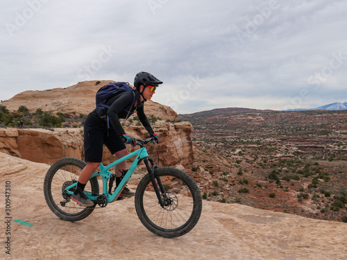 Obraz na płótnie Young woman riding mountain bikes on singletrack in Moab, Utah w salonie