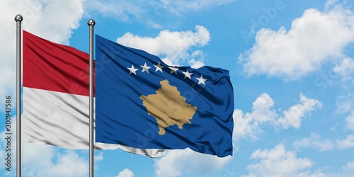 Iraq and Kosovo flag waving in the wind against white cloudy blue sky together. Diplomacy concept, international relations.