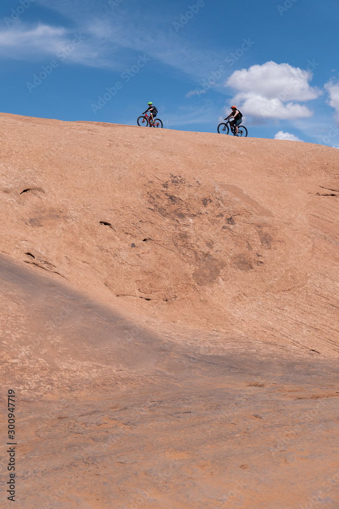 Son and mother riding mountain bikes of singletrack in Moab, Utah