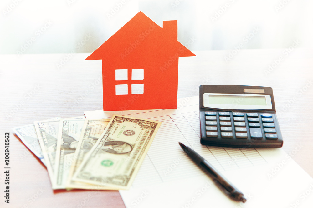 Buying and selling houses and real estate prices. Concept. Man using calculator to count rent money.