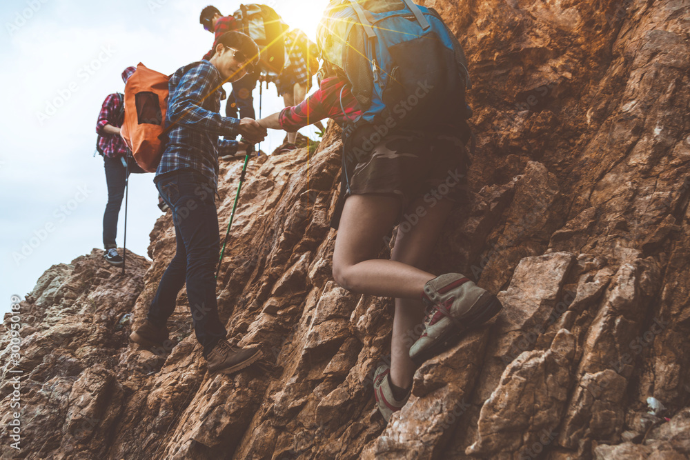 Obraz premium Hiking team, teamwork concept, successful team, successful team standing on the top of the mountain, a team of male and female climbers raised