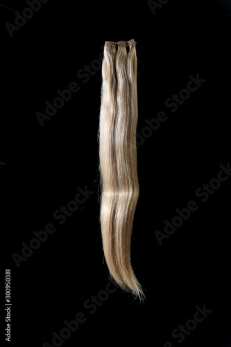 Hair extensions of various colors on a dark background.