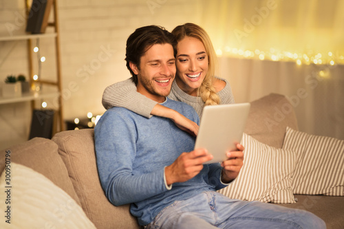 Happy couple having video-call on tablet, free space