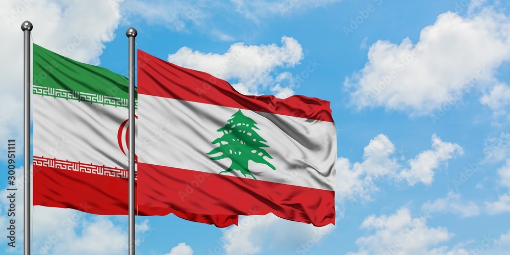 Obraz premium Iran and Lebanon flag waving in the wind against white cloudy blue sky together. Diplomacy concept, international relations.