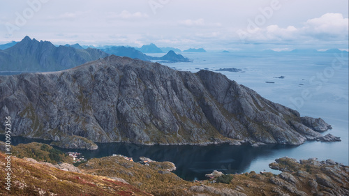 View of the fishing town of Nusfjord, Norway, Lofoten islands, golden autumn surrounded by colorful mountains and blue water